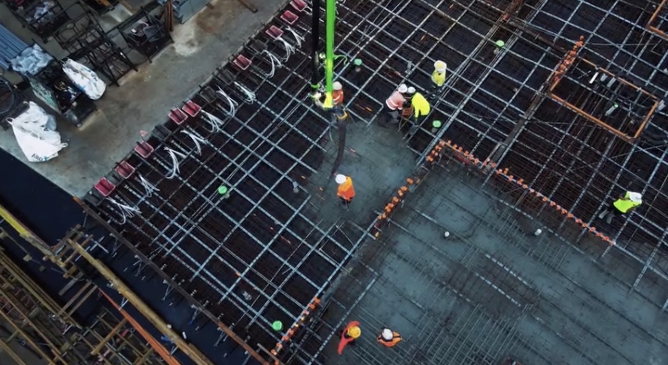 Aerial view of industrial concrete pour with crew and rebar